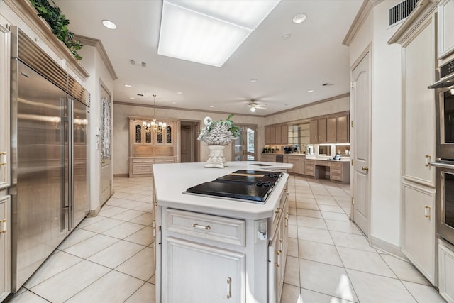 903 Old Lake Rd, Houston, TX 77057 - kitchen featuring appliances with stainless steel finishes, light tile patterned flooring, a kitchen island, ornamental molding, and light countertops