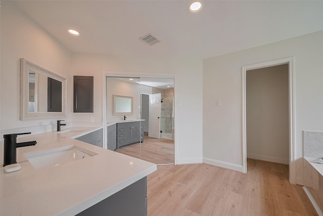2543 Forge Stone Dr, Friendswood, TX 77546 - full bathroom with two vanities, wood finished floors, a stall shower, recessed lighting, and a bathtub