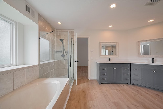 2543 Forge Stone Dr, Friendswood, TX 77546 - bathroom featuring a stall shower, a bath, double vanity, wood finished floors, and recessed lighting