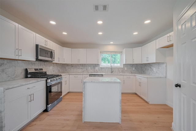 2543 Forge Stone Dr, Friendswood, TX 77546 - kitchen featuring appliances with stainless steel finishes, a sink, recessed lighting, a center island, and white cabinets