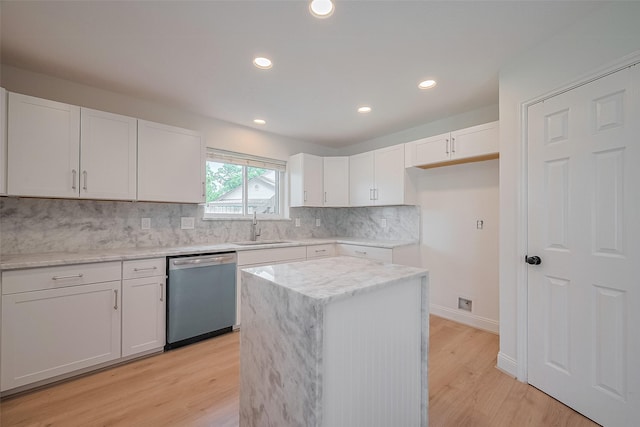 2543 Forge Stone Dr, Friendswood, TX 77546 - kitchen with stainless steel dishwasher, a sink, white cabinets, light wood-style flooring, and tasteful backsplash