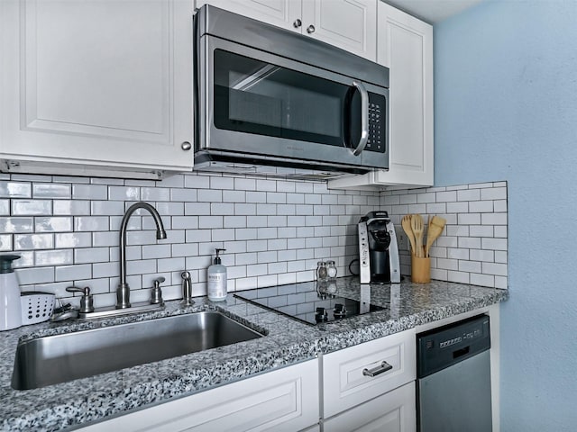 6300 Seawall Blvd Unit 3123, Galveston, TX 77551 - kitchen featuring appliances with stainless steel finishes, a sink, decorative backsplash, and white cabinetry