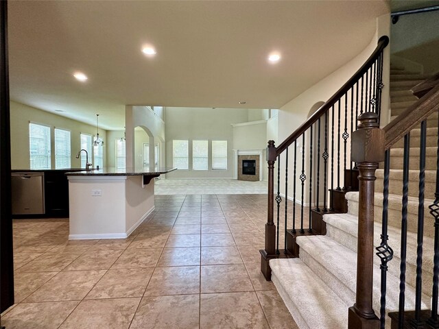 9314 Wheatfield Ln, Rosenberg, TX 77469 - stairs featuring recessed lighting, healthy amount of natural light, a tile fireplace, tile patterned flooring, and baseboards