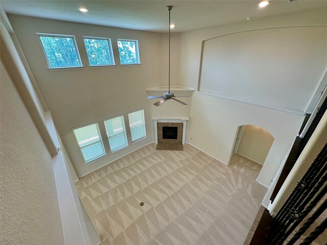 9314 Wheatfield Ln, Rosenberg, TX 77469 - unfurnished living room featuring a ceiling fan, a fireplace, recessed lighting, carpet flooring, and a high ceiling