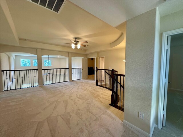 9314 Wheatfield Ln, Rosenberg, TX 77469 - carpeted spare room with a raised ceiling, ceiling fan, arched walkways, baseboards, and a textured wall