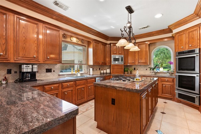 5706 Amber Queen Ct, Houston, TX 77041 - kitchen featuring a warming drawer, stainless steel appliances, brown cabinets, a center island, and light tile patterned floors