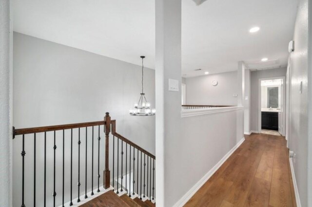 910 S Chamfer Way, Crosby, TX 77532 - corridor with wood finished floors, an upstairs landing, a chandelier, recessed lighting, and baseboards