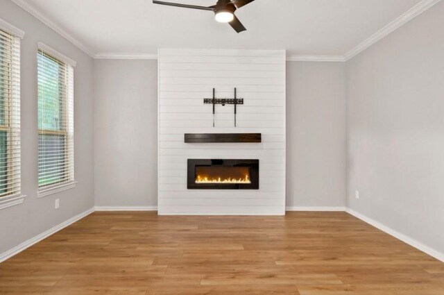 910 S Chamfer Way, Crosby, TX 77532 - unfurnished living room with crown molding, ceiling fan, light wood-style flooring, a fireplace, and baseboards