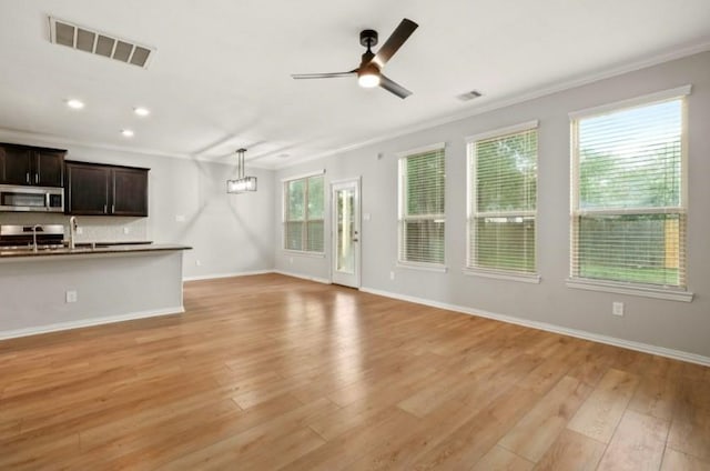 910 S Chamfer Way, Crosby, TX 77532 - unfurnished living room featuring ornamental molding, ceiling fan, light wood-style floors, baseboards, and recessed lighting