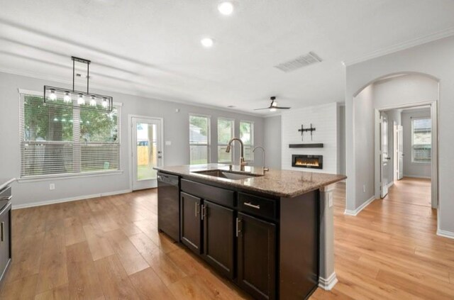 910 S Chamfer Way, Crosby, TX 77532 - kitchen with a sink, dishwasher, open floor plan, arched walkways, and light stone counters