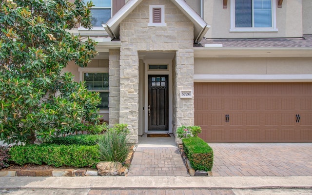 5726 Brancott Way, Houston, TX 77096 - doorway to property featuring stucco siding, an attached garage, stone siding, driveway, and roof with shingles