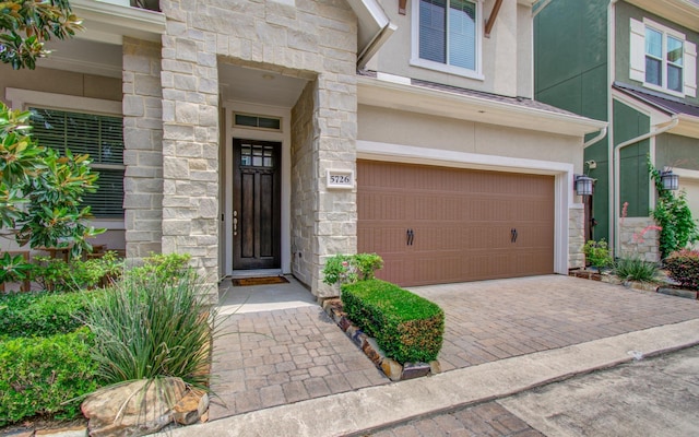 5726 Brancott Way, Houston, TX 77096 - property entrance featuring stone siding, stucco siding, a garage, and driveway