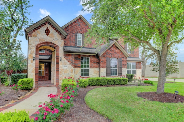 5402 Bending Branch Dr, Missouri City, TX 77459 - view of front facade featuring stone siding, a front yard, brick siding, and roof with shingles