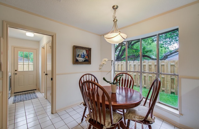 6119 Bankside Dr, Houston, TX 77096 - dining area featuring light tile patterned flooring, wainscoting, ornamental molding, and a decorative wall