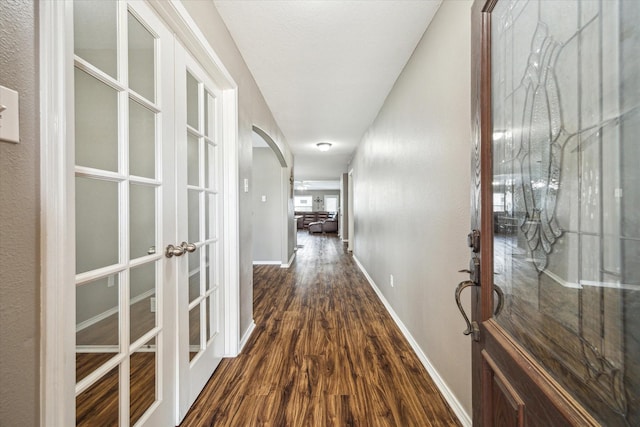 11203 Riata Canyon Dr, Cypress, TX 77433 - hall featuring french doors, arched walkways, dark wood-type flooring, and baseboards