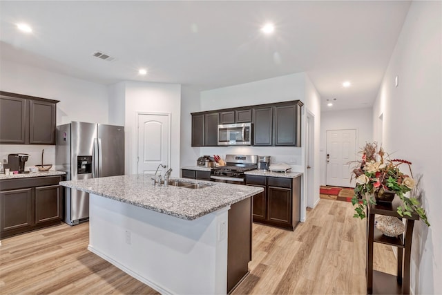 15007 Ashton Meadows Dr, New Caney, TX 77357 - kitchen with stainless steel appliances, a sink, light wood-type flooring, a center island with sink, and recessed lighting