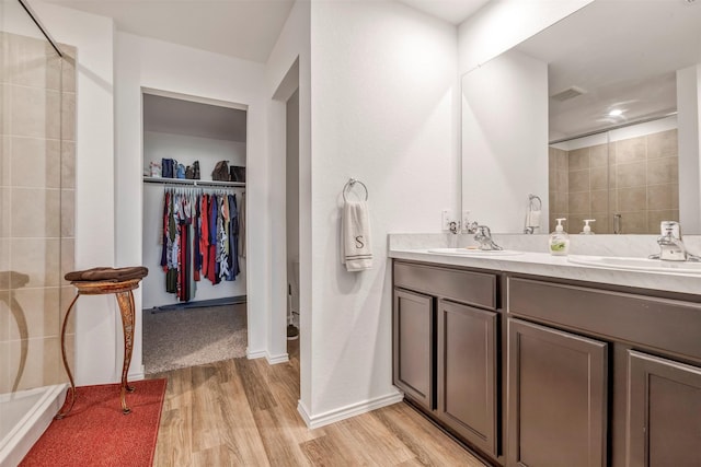 15007 Ashton Meadows Dr, New Caney, TX 77357 - bathroom featuring a stall shower, wood finished floors, a walk in closet, and double vanity