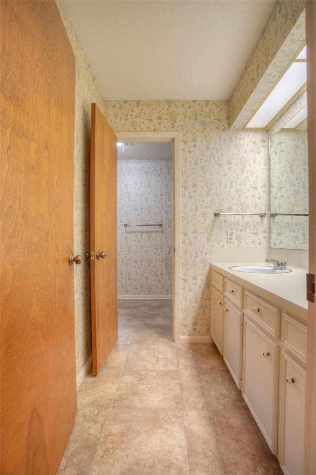 333 Hardy St, Huntsville, TX 77340 - bathroom featuring vanity, wallpapered walls, and baseboards