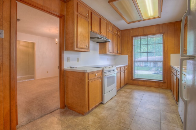 333 Hardy St, Huntsville, TX 77340 - kitchen featuring white range with electric cooktop, under cabinet range hood, light countertops, brown cabinetry, and light tile patterned floors