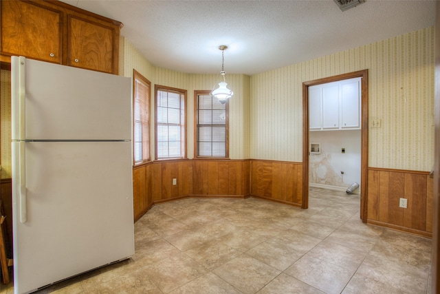 333 Hardy St, Huntsville, TX 77340 - unfurnished dining area with a wainscoted wall, wood walls, wallpapered walls, and a textured ceiling
