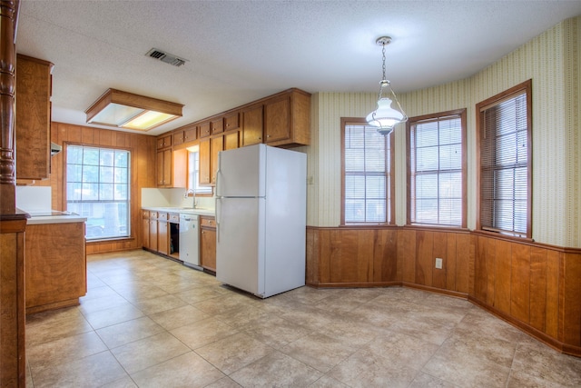 333 Hardy St, Huntsville, TX 77340 - kitchen featuring white appliances, brown cabinets, a sink, light countertops, and a textured ceiling