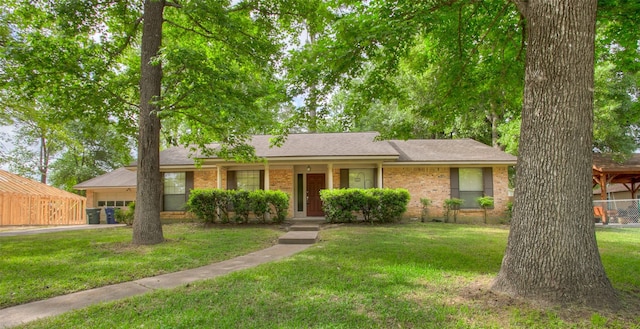 333 Hardy St, Huntsville, TX 77340 - ranch-style home with a front lawn, an attached garage, brick siding, a shingled roof, and driveway