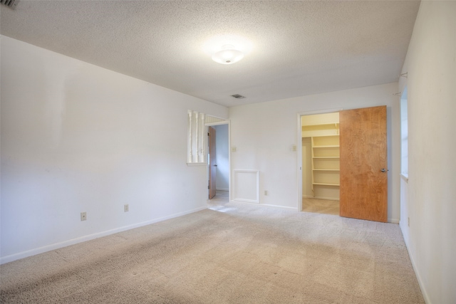 333 Hardy St, Huntsville, TX 77340 - spare room featuring light colored carpet, a textured ceiling, and baseboards