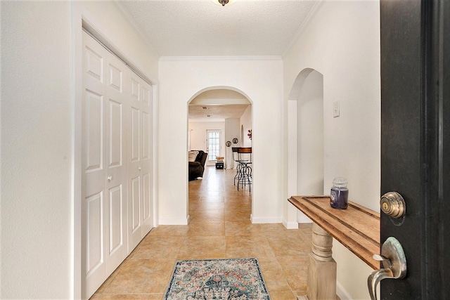 116 Whiting St, Galveston, TX 77550 - hall featuring arched walkways, ornamental molding, a textured ceiling, light tile patterned floors, and baseboards