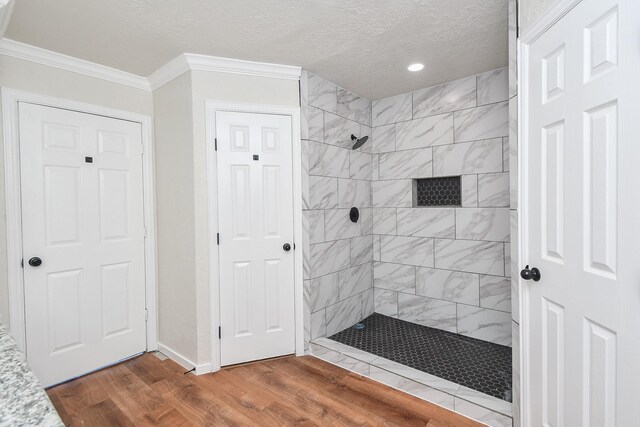 4618 Turf Valley Dr, Houston, TX 77084 - full bath featuring a tile shower, wood finished floors, baseboards, a textured ceiling, and crown molding