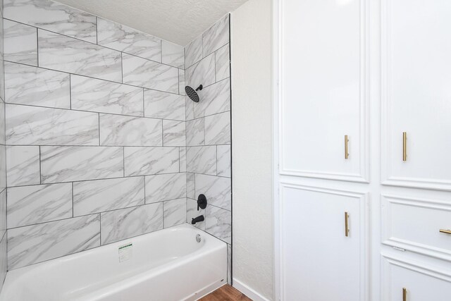 4618 Turf Valley Dr, Houston, TX 77084 - bathroom featuring shower / bath combination, a textured ceiling, and wood finished floors
