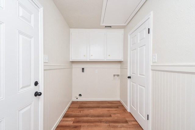 4618 Turf Valley Dr, Houston, TX 77084 - laundry room featuring cabinet space, hookup for an electric dryer, wainscoting, wood finished floors, and washer hookup