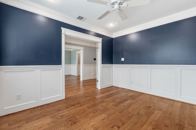 1510 Marshall St, Houston, TX 77006 - unfurnished room featuring crown molding, ceiling fan, a wainscoted wall, wood finished floors, and a decorative wall