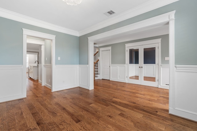 1510 Marshall St, Houston, TX 77006 - spare room with stairs, wainscoting, wood finished floors, crown molding, and french doors
