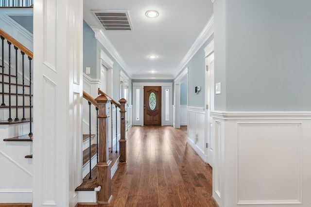 1510 Marshall St, Houston, TX 77006 - foyer entrance featuring stairway, wood finished floors, ornamental molding, a decorative wall, and a wainscoted wall