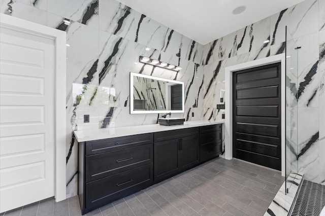 10070 Cedardale Dr, Houston, TX 77055 - bathroom featuring vanity, a marble finish shower, tile walls, and wood finished floors