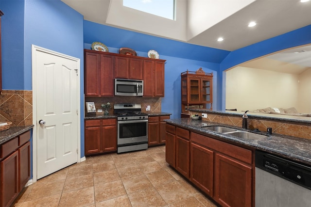 1027 Nantucket St, Pasadena, TX 77503 - kitchen with stainless steel appliances, a sink, backsplash, dark stone countertops, and a towering ceiling