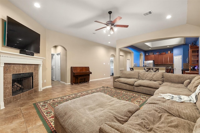 1027 Nantucket St, Pasadena, TX 77503 - living area featuring arched walkways, a ceiling fan, light tile patterned floors, a fireplace, and baseboards