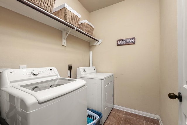 1027 Nantucket St, Pasadena, TX 77503 - laundry area featuring washing machine and clothes dryer, baseboards, and dark tile patterned flooring