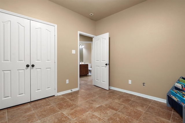 1027 Nantucket St, Pasadena, TX 77503 - unfurnished bedroom featuring baseboards, light stone finish flooring, and a closet
