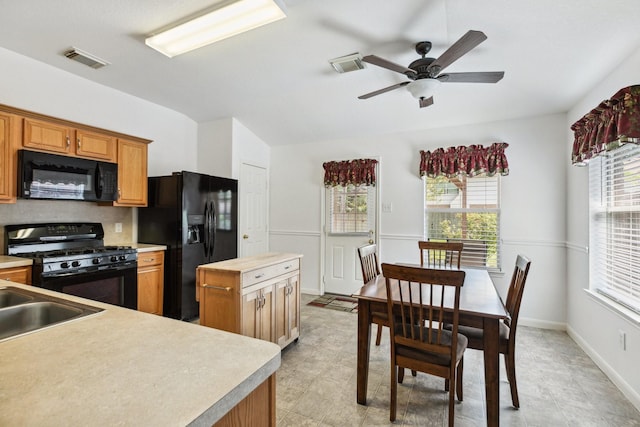 19119 Mossy Hedge Ln, Katy, TX 77449 - kitchen with black appliances, ceiling fan, baseboards, brown cabinetry, and a sink