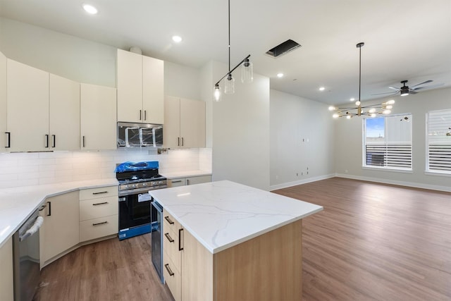 1932 Purswell Rd, Houston, TX 77055 - kitchen featuring stainless steel appliances, light wood-style flooring, a center island, backsplash, and baseboards