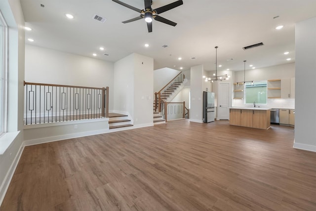 1932 Purswell Rd, Houston, TX 77055 - unfurnished living room with ceiling fan, wood finished floors, a chandelier, a sink, and baseboards