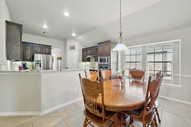 20688 Oakhurst Meadows Dr, Porter, TX 77365 - dining space featuring light tile patterned flooring, arched walkways, vaulted ceiling, baseboards, and recessed lighting