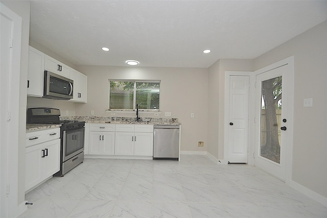 631 Aweigh Dr, Crosby, TX 77532 - kitchen with stainless steel appliances, light stone counters, light marble finish flooring, a sink, and white cabinets