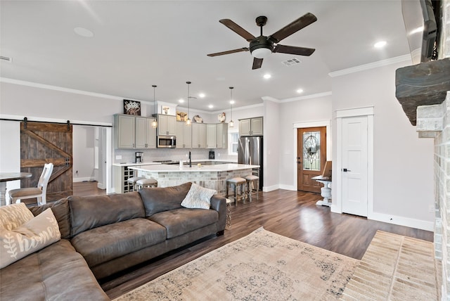 12078 County Road 175, Iola, TX 77861 - living room with baseboards, ceiling fan, dark wood-style flooring, ornamental molding, and a barn door