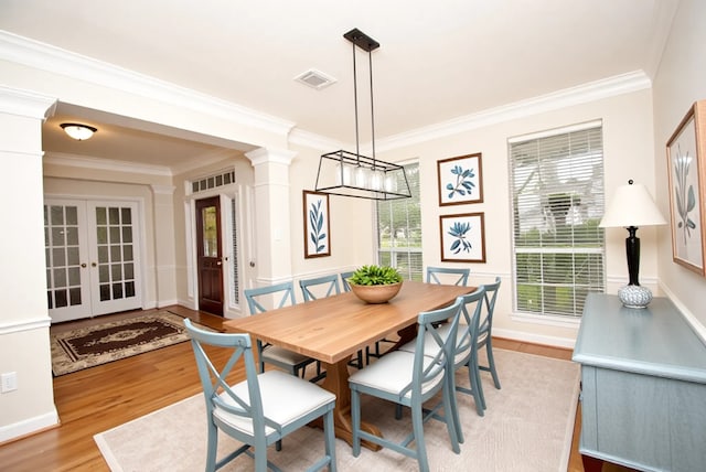 1902 Rosebay Ct, Sugar Land, TX 77479 - dining area with wood finished floors, crown molding, ornate columns, french doors, and a chandelier