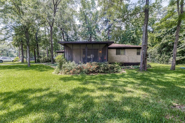119 Delaware Dr, Conroe, TX 77316 - rear view of house with a yard and a sunroom