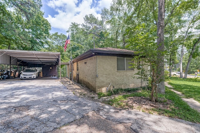 119 Delaware Dr, Conroe, TX 77316 - view of home's exterior featuring driveway, a carport, and brick siding