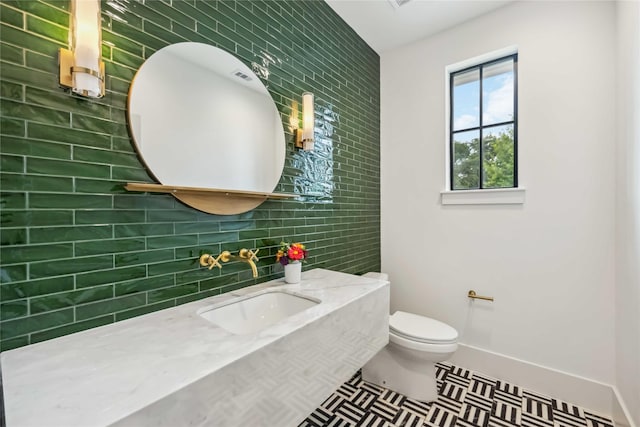 1913 Ebony Ln, Houston, TX 77018 - half bath featuring tile walls, toilet, vanity, tile patterned flooring, and tasteful backsplash
