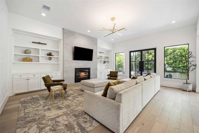 1913 Ebony Ln, Houston, TX 77018 - living area featuring baseboards, a large fireplace, light wood-style flooring, a chandelier, and recessed lighting